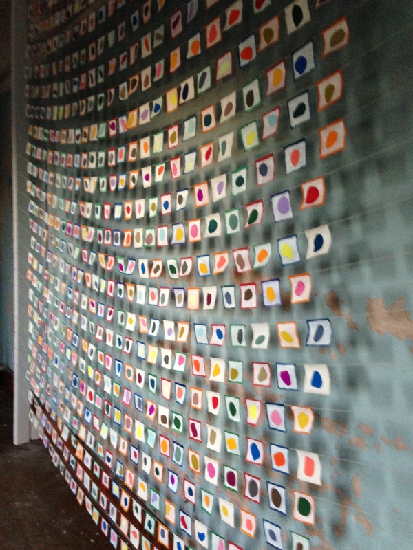 625 rocks, installed at the Goff Street Armory, New Haven, CT Miscellany acryla gouache, graphite, and B-I-N on the reverse side of 625 2.875-x-2.875-inch paper Tibetan prayer flags, installed on a wall