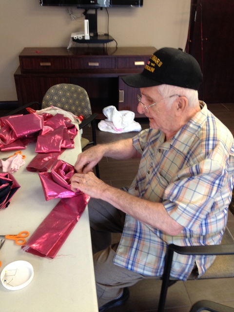 Senior community member hand sews Resiliency Rose at Maker Party. Push Down & Tango