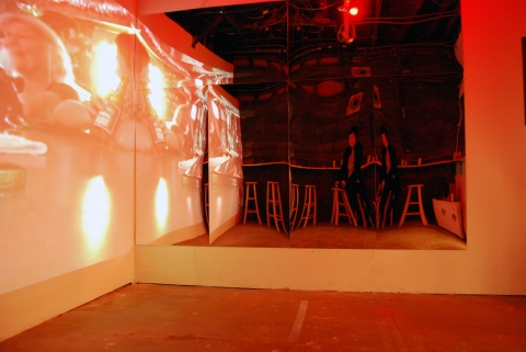 The Last Resort - Installation View, Krowswork Gallery - Oakland, CA Cybele Lyle The Last Resort at Krowswork Gallery Video Projection, Wood Stools, Wood Bar, Mirrored Plexi, Dart Board, Red Light, Beer