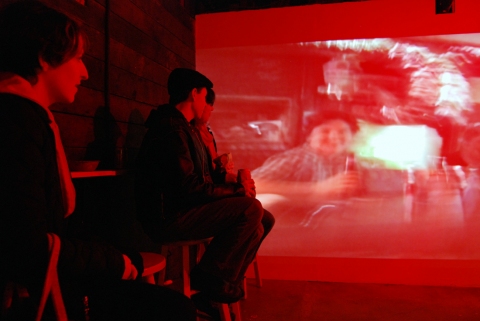 The Last Resort - Installation View, Krowswork Gallery - Oakland, CA Cybele Lyle The Last Resort at Krowswork Gallery Video Projection, Wood Stools, Wood Bar, Mirrored Plexi, Dart Board, Red Light, Beer