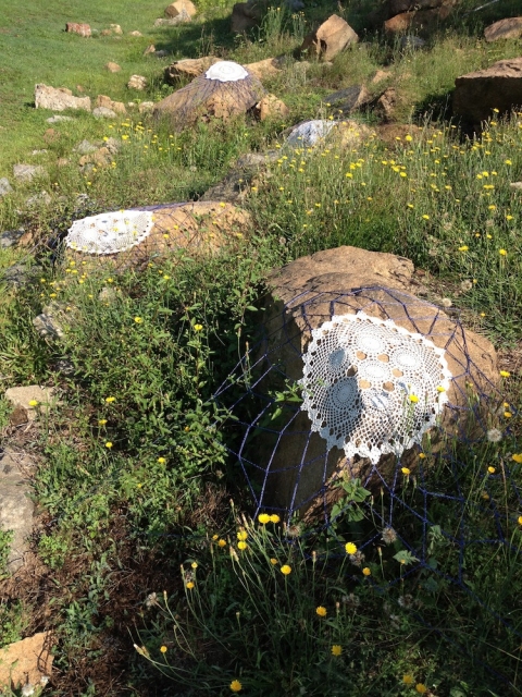 Dwell s i t e specific one dozen cotton doilies stretched over found rocks