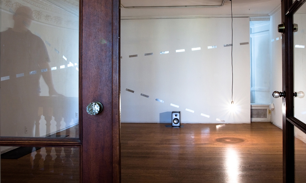 THIS IS THE SOUND OF THE MILKY WAY mark booth THIS IS THE SOUND OF THE MILKY WAY Three channel audio(endless loop), light, absented Flamarrion Book of Astronomy, appropriated image of the galaxy from the Charles and Ray Eames Studio, loudspeakers, and silver adhesive tape