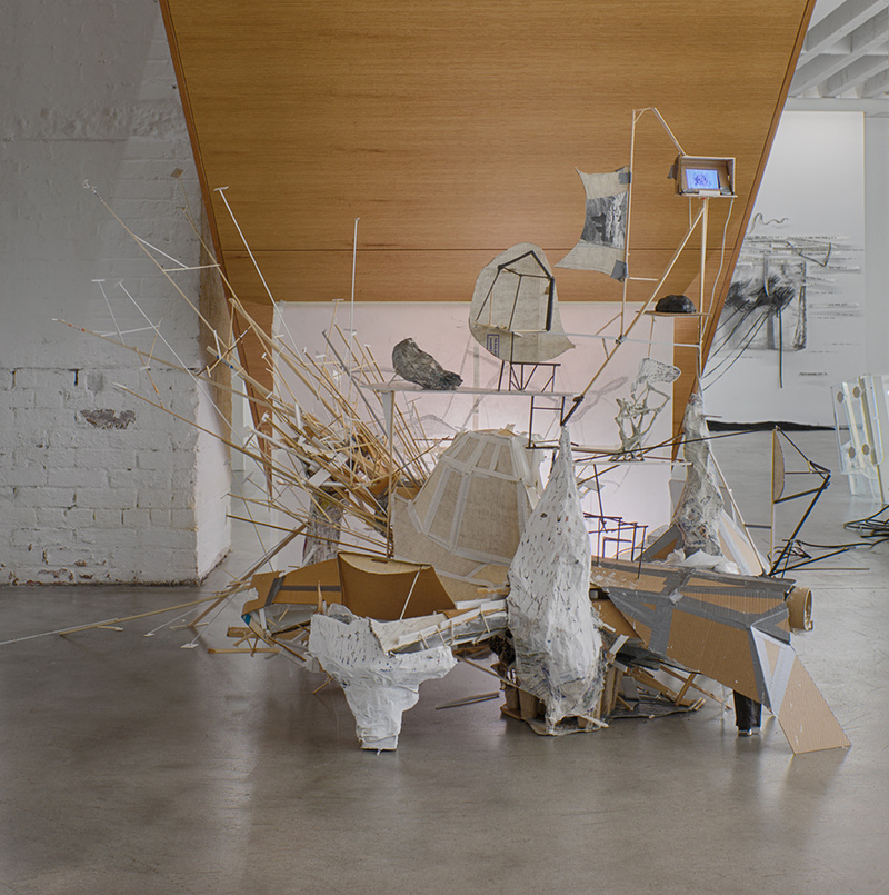 After Lebbeus: A Model For Drawing Patte Loper Sculpture, Installation, and Video Salvaged material, duct tape, latex paint, DVD player, iPod Touch, animated video shown as a loop
