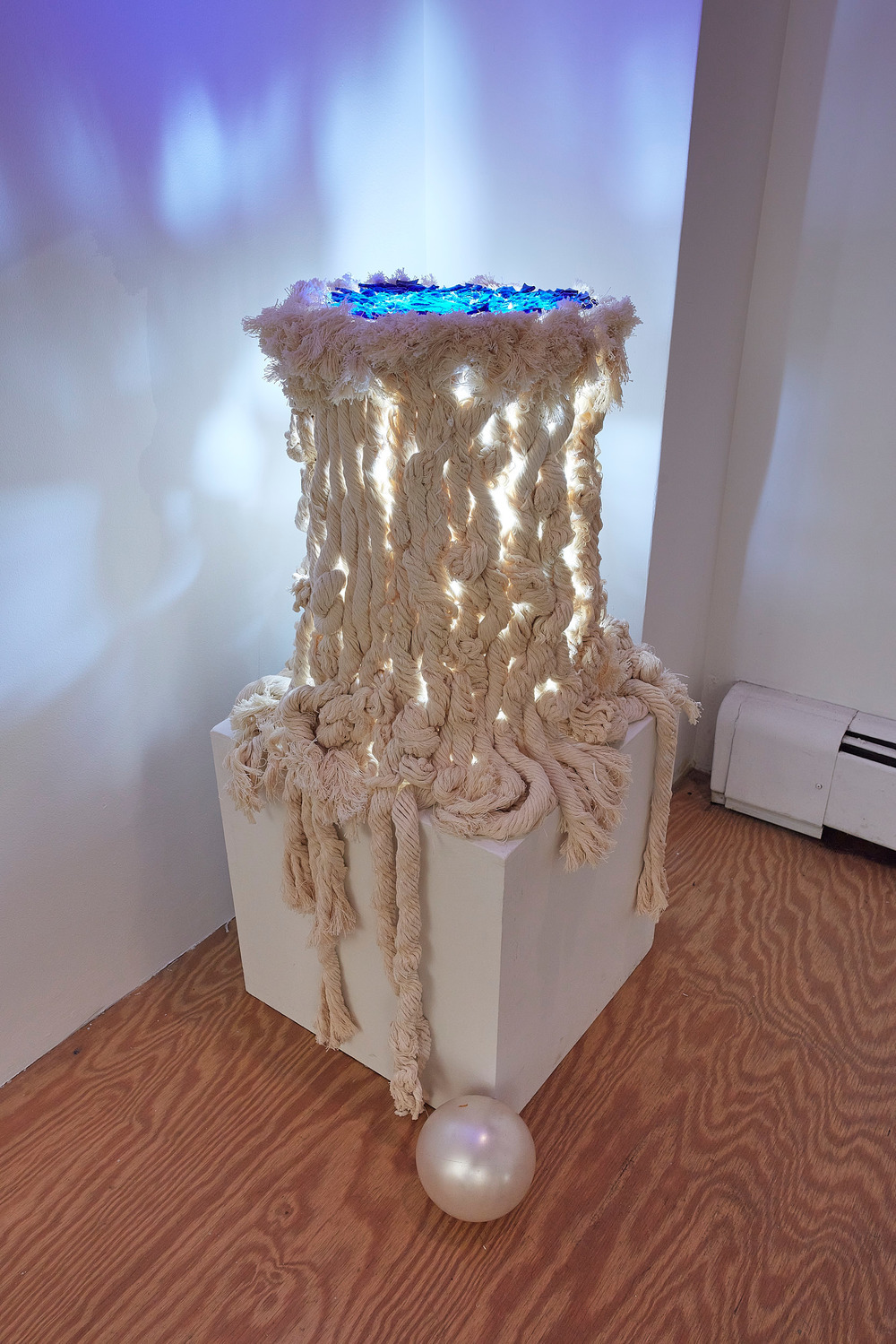  2022  re-used cotton rope, found glass from water bottles, found light, balsa wood, found child’s ball, velcro, pedestal