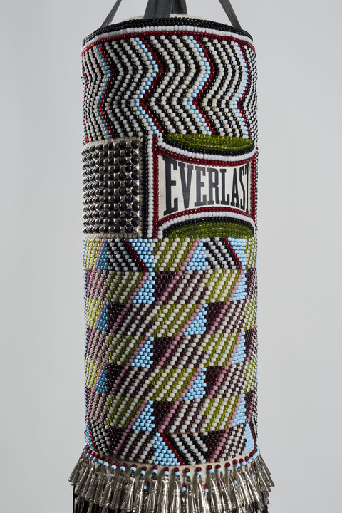  Hit That Perfect Beat found punching bag, repurposed wool blanket, glass beads, steel studs, tin jingles, nylon fringe, artificial sinew, steel chains