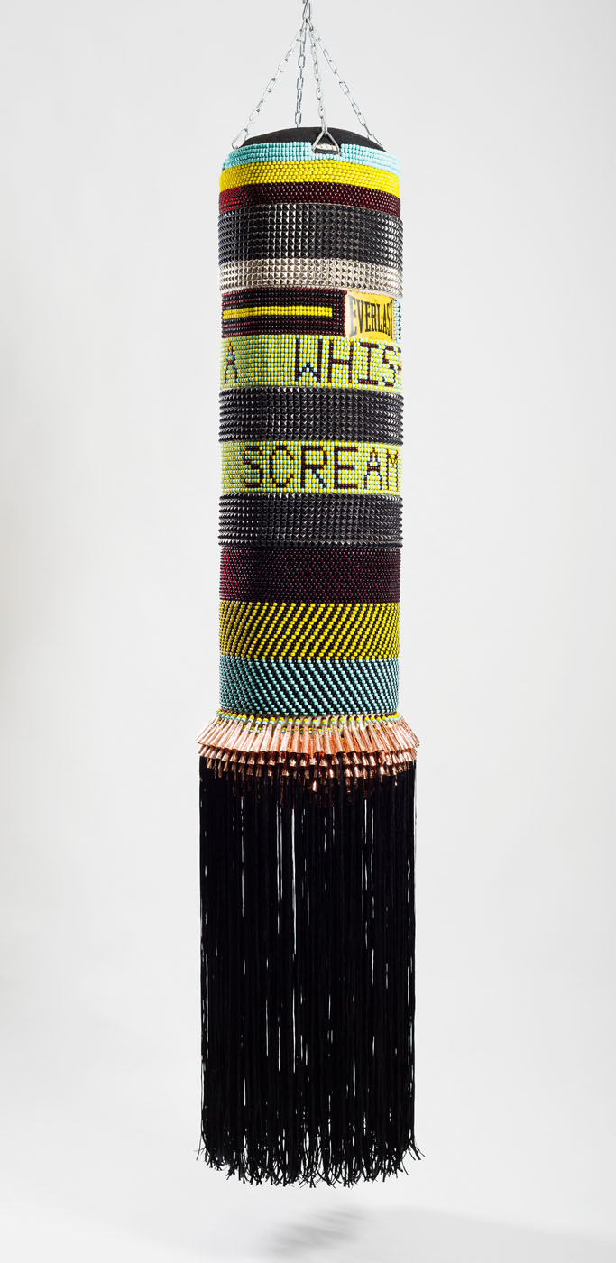  FROM A WHISPER TO A SCREAM found canvas punching bag, repurposed wool army blanket, glass beads, steel studs, artificial sinew, nylon fringe, copper jingles, steel chain 