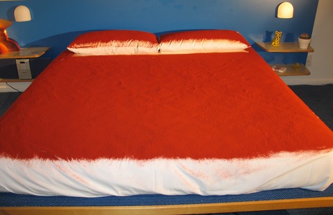 Martha Schlitt INSTALLATIONS paprika, hotel bed and linens