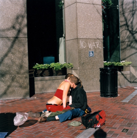 Couple on ecstasy cuddling during an anti-war protest, San Francisco